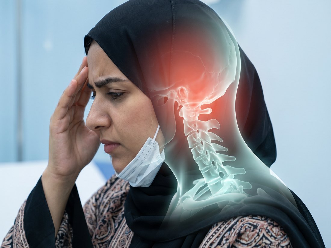 Woman wearing a hijab holding her forehead, with a red glow running from the neck up into the head