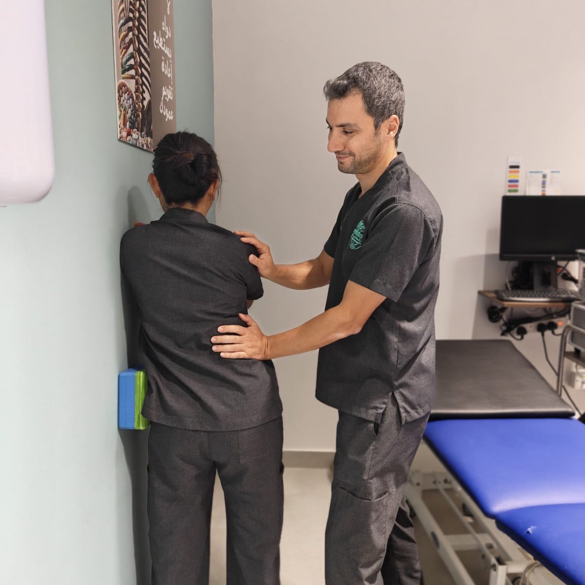 Physiotherapist assessing spinal posture during corrective exercise, CBPSJ Muscat