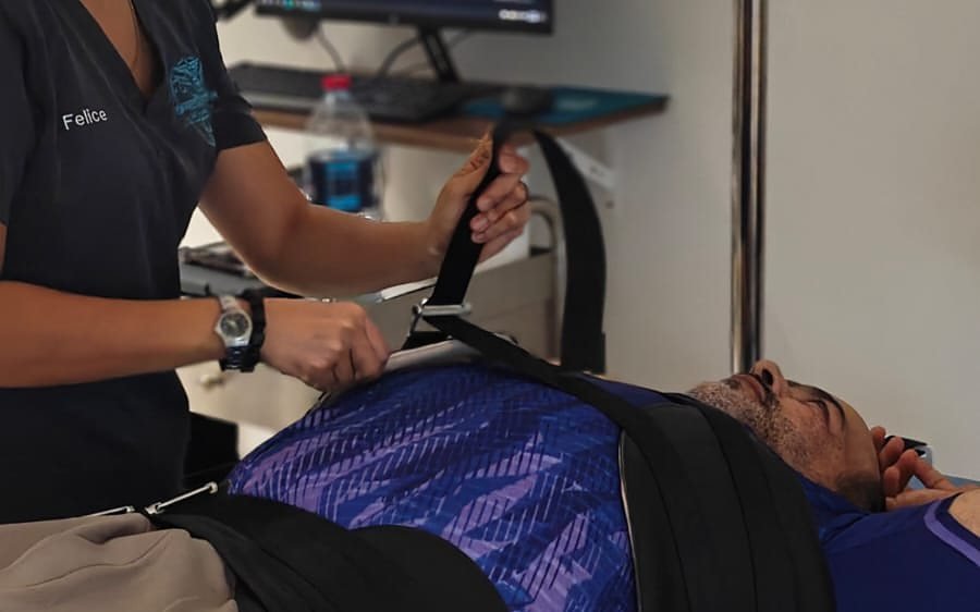 Physiotherapist fitting the decompression harness on a patient during spinal decompression therapy at CBP Precision Spine Center