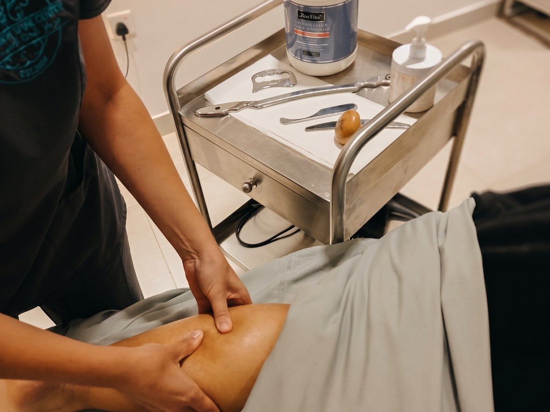 Therapist performing therapeutic soft-tissue massage on a leg